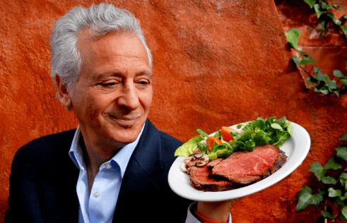 Pierre Dukan hält einen Teller mit Proteinprodukten in der Hand